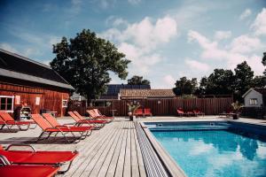 een terras met stoelen en een zwembad bij Hotel Toftagården in Tofta