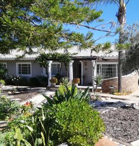 a white house with trees in front of it at Voni's Cottage in Vredendal