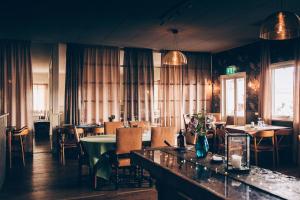 a restaurant with tables and chairs and a bar at Hotel Toftagården in Tofta