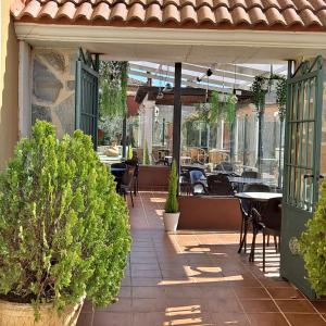 an outdoor patio with tables and chairs and plants at HOTELSANMARTIN in Frómista
