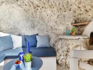 - un salon avec un canapé bleu et une table dans l'établissement La Cueva de Caleta by VillaGranCanaria, à Gáldar