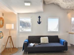 - un salon avec un canapé bleu et 2 fenêtres dans l'établissement La Cueva de Caleta by VillaGranCanaria, à Gáldar
