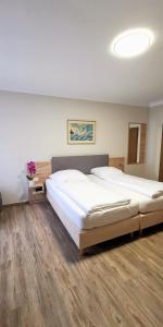 2 Betten in einem Zimmer mit Holzböden in der Unterkunft Zum Winzermännle in Würzburg