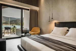 a bedroom with a bed and a view of the water at Canale Hotel & Suites in Argostoli