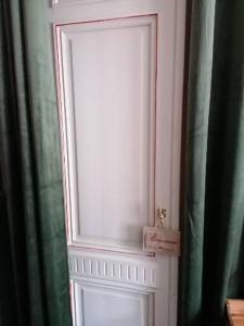 - une porte blanche avec une fenêtre dans la chambre dans l'établissement Maison d'hôte Les Notes Endormie Chambre Secrète, à Berzée