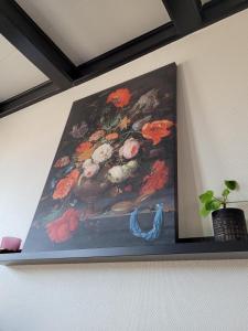 una pintura de una pintura de flores en una pared en B&B Diepzicht, en Dokkum