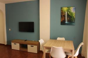 een eetkamer met een tafel en een tv bij Apartamentos Esteasur Islantilla in Islantilla
