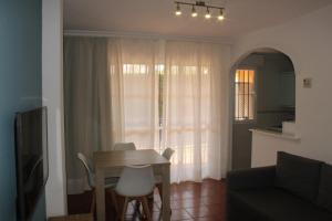 een woonkamer met een tafel en een bank bij Apartamentos Esteasur Islantilla in Islantilla