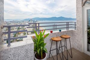 a balcony with two stools and a view of the city at Kim Ngan Phat Deluxe Apartment in Danang
