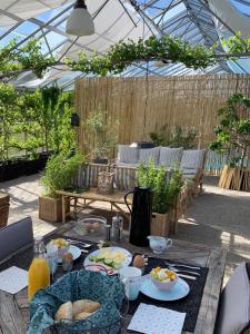 a table with plates of food on it in a garden at Mariegaardens Gæstehuse in Hillerød