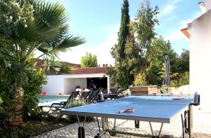 a ping pong table in the backyard of a house at Casas e Glamping Quinta da Saudade in Canha