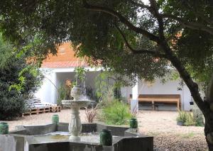 a fountain in the middle of a yard with a bench at Casas e Glamping Quinta da Saudade in Canha