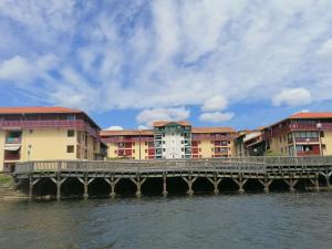 a bridge over the water in front of buildings at appartement T2bis idealement situé au bord du lac marin de Vieux Boucau in Vieux-Boucau-les-Bains