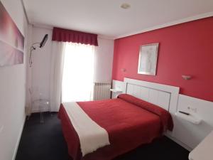 a red bedroom with a bed and a red wall at HOTELSANMARTIN in Frómista