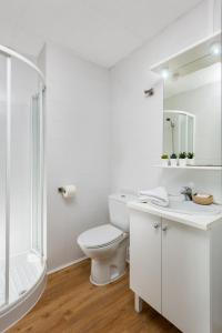 a white bathroom with a toilet and a sink at Micampus UPO Celestino Mutis Student Residence in Seville