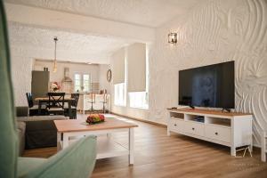 Una sala de estar con un televisor de pantalla plana en una pared. en Villa Pepina, en Risika