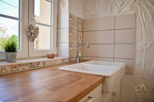 baño con lavabo blanco y ventana en Villa Pepina, en Risika 29 fotos más