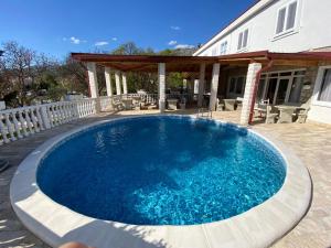 a large blue swimming pool in front of a house at Vila Punta in Šibuljina