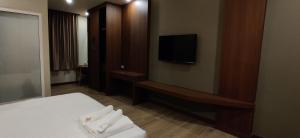 a hotel room with a bed and a flat screen tv at หอพัก ทูเอ็มเพลส 2M Place Apartment in Ban Khlong Nung