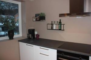 a kitchen with a counter with bottles on the wall at Meget flott leilighet i Stryn sentrum in Stryn