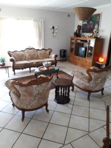 a living room with couches and a tv at The Manse in Port Shepstone
