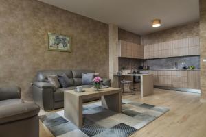 una sala de estar con un sofá y una mesa en Boutique Apartments - Sevtopolis, en Kazanlak