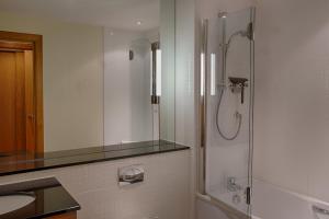 a bathroom with a shower and a sink at Links Apartment in Brora