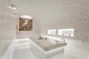 Wellness СПА-Отель Грейс Горизонт في سوتشي: حمام ابيض مع حوض و لوحة على الحائط