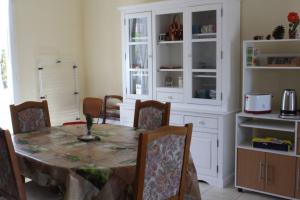 a dining room with a table and chairs and a kitchen at Le Lizard, un gîte pour vos passions nature in Château-du-Loir