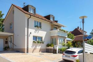 una casa blanca con un coche aparcado delante en Ferienwohnung Bodensee Fisch, en Meersburg