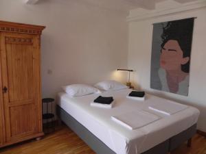a bedroom with a white bed with a painting on the wall at Villa By The Sea Near Dubrovnik in Cavtat