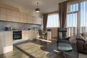 a living room with a chair and a kitchen at Boutique Apartments - Sevtopolis in Kazanlŭk