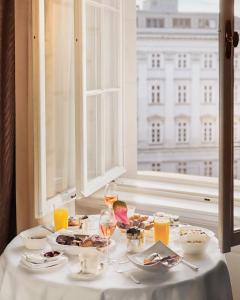 a table with food and wine glasses and a window at Park Hyatt Vienna in Vienna