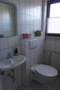 uma casa de banho branca com um WC e um lavatório em Haus Eifeldolomiten - Ankommen und Wohlfühlen em Gerolstein