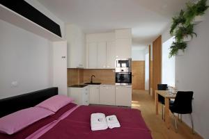 1 dormitorio con 1 cama y 2 toallas blancas en Cirus apartments en Kočevje