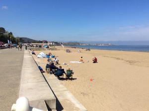 a group of people sitting on the beach at One bedroom flat on a quiet road in Colwyn Bay