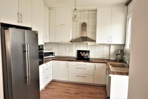 a kitchen with white cabinets and a stainless steel refrigerator at Katerinas House in Nikiti