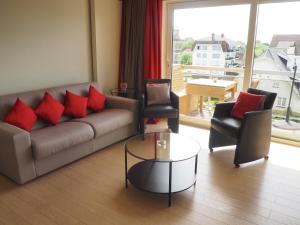 een woonkamer met een bank, 2 stoelen en een tafel bij Appartement sur la digue - De Haan - Le Coq - Silver Beach D2 in De Haan