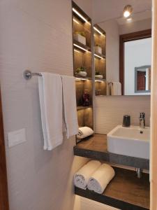 a bathroom with a sink and a mirror and towels at Hotel Antica Cascina Del Golfo in Scopello