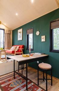 sala de estar con mesa y pared verde en TinyParks Forest Cabins, en Hoogersmilde