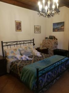 a bedroom with a bed and a chandelier at B&B Antica Corte Lombarda in Mortara