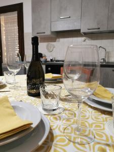 una mesa con copas de vino y una botella de vino en MG CASA VACANZE FAVIGNANA en Favignana