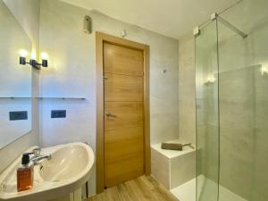 łazienka z umywalką i przeszkloną kabiną prysznicową w obiekcie Menditxo Eder Rooms w mieście San Sebastián