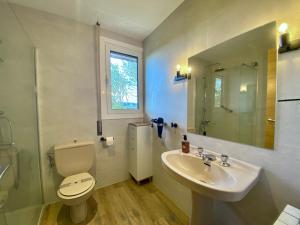 łazienka z białą toaletą i umywalką w obiekcie Menditxo Eder Rooms w mieście San Sebastián