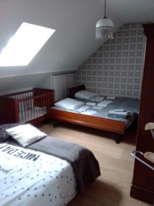 a bedroom with two beds in a attic at La longère in Épineu-le-Chevreuil