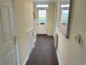 a hallway with a white door and a window at St Margarets House - Modern - 3 Bed Townhouse - Parking - Marvello Properties in Norwich