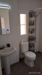 baño con aseo y lavabo y ventana en Inviting 1-Bed Apartment on Castillo Mar, en Caleta de Fuste