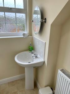 baño con lavabo, espejo y ventana en St Margarets House - Modern - 3 Bed Townhouse - Parking - Marvello Properties, en Norwich