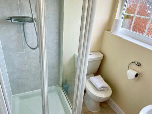 a bathroom with a toilet and a glass shower at St Margarets House - Modern - 3 Bed Townhouse - Parking - Marvello Properties in Norwich
