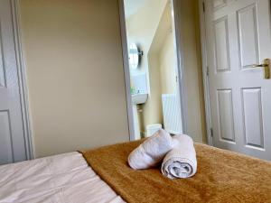 a bedroom with two towels sitting on a bed at St Margarets House - Modern - 3 Bed Townhouse - Parking - Marvello Properties in Norwich